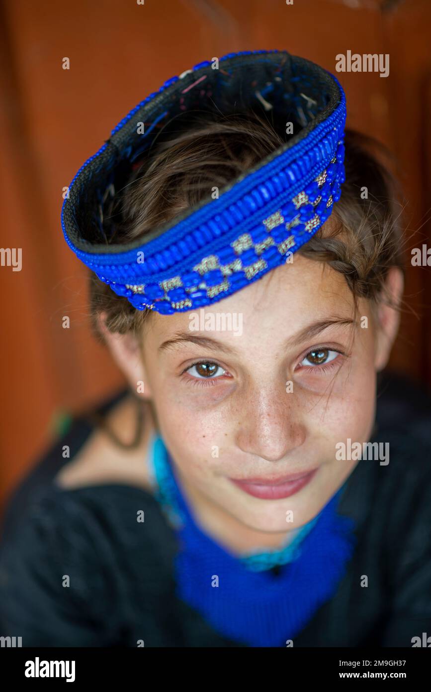 Porträt eines Kalash-Mädchens mit farbenfroher traditioneller Kopfbedeckung, Bumburet Valley, Pakistan Stockfoto