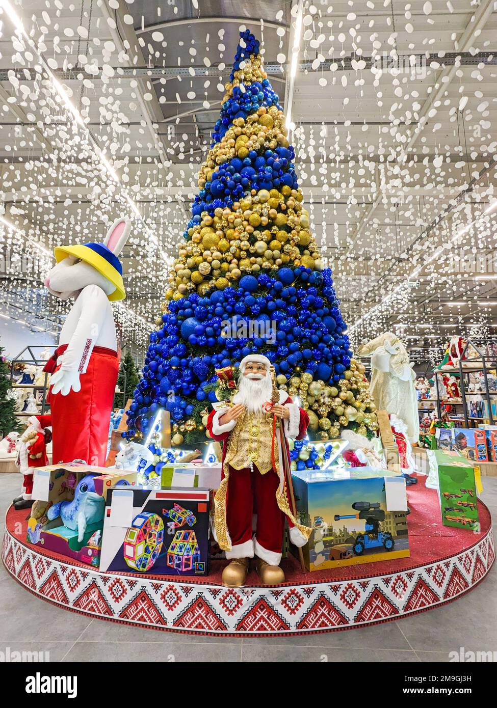 Der Weihnachtsmann und das Symbol von 2023 Hasen in der Nähe des Weihnachtsbaums im Supermarkt. Dnipro, Ukraine, 6. Januar 2023. Stockfoto