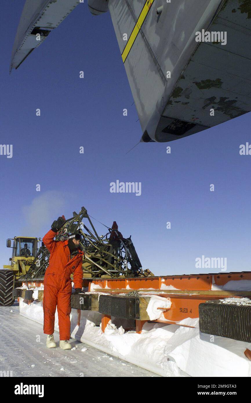 MASTER Sergeant Robert Lesnick, ein Ladermeister mit dem 730. Airlift-Geschwader, March Air Reserve Base, Kalifornien, führt den Frachtschlitten, während er von der Rampe eines C-141C Starlifters weggezogen wird. Das Flugzeug steht auf dem Ross-Eisregal in der Nähe der McMurdo-Station in der Antarktis, während der Operation DEEP FREEZE 2001. Betreff Operation/Serie: TIEFKÜHL 2001 Basis: McMurdo Station Country: Antarktis (ATA) Stockfoto