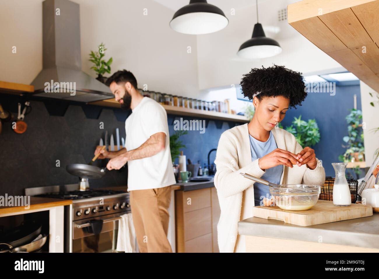 Birassischer junger Freund und Freundin, die zu Hause in der Küche frühstücken Stockfoto