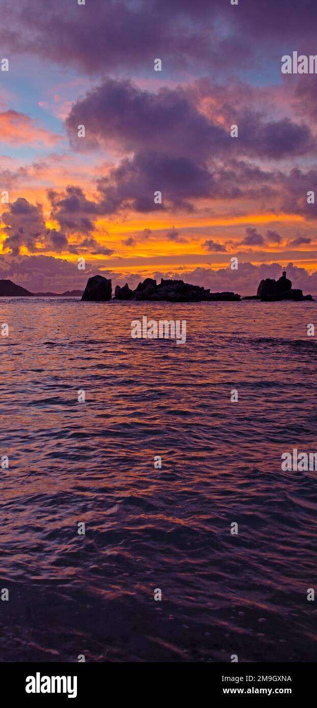 Marine mit Felsformationen unter Moody Himmel bei Sonnenuntergang Silhouette, La Digue, Seychellen Stockfoto