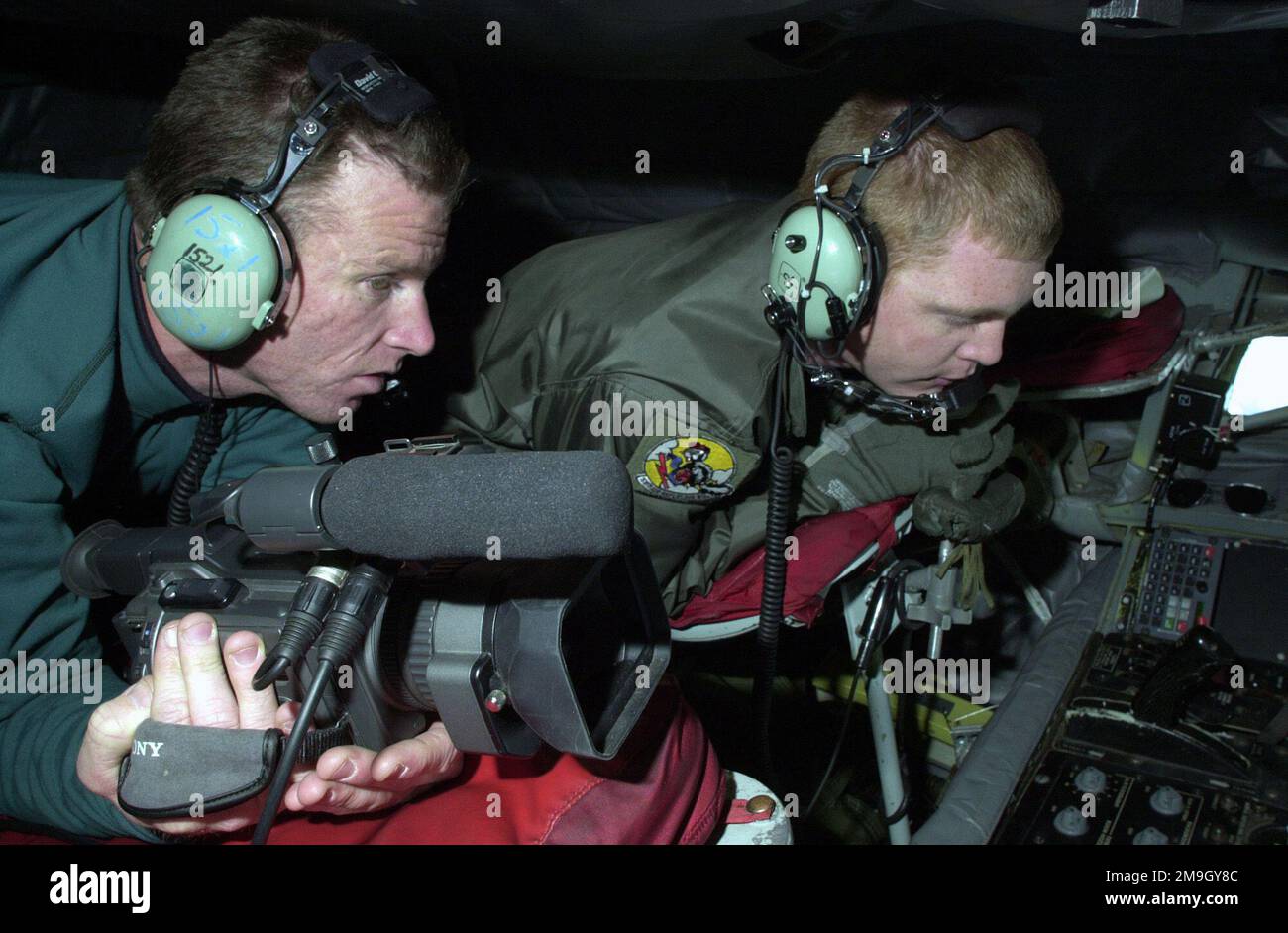 Der KTUU-Fotojournalist Tom Cole (links) und SENIOR AIRMAN (SRA) Jeremy Vancil, SPEZIALIST für Luftbetankung an Bord, erwarten die Ankunft eines Flugzeugs, um mit dem Betanken aus dem KC-135R Stratotanker zu beginnen. SRA Vancil ist ein traditioneller Wachmann mit dem 168. Air Tanken Squadron und aktiviert, um zusätzliche qualifizierte Arbeitskräfte aufgrund der verstärkten Aktivität für die Operation NOBLE EAGLE bereitzustellen. SRA Vancil ist Junior an der University of Alaska, Fairbanks, wo seine Professoren seinen Zeitplan einhalten, damit er seine Ausbildung fortsetzen und gleichzeitig die Bedürfnisse des Landes erfüllen kann. Der Medienfluginitiat Stockfoto