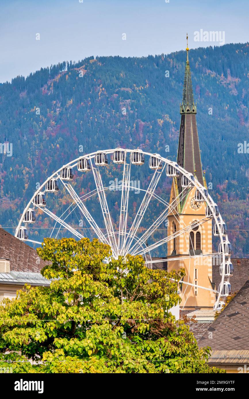 Blick auf das Riesenrad und den Glockenturm der Nikolaikirche; Villach, Österreich Stockfoto