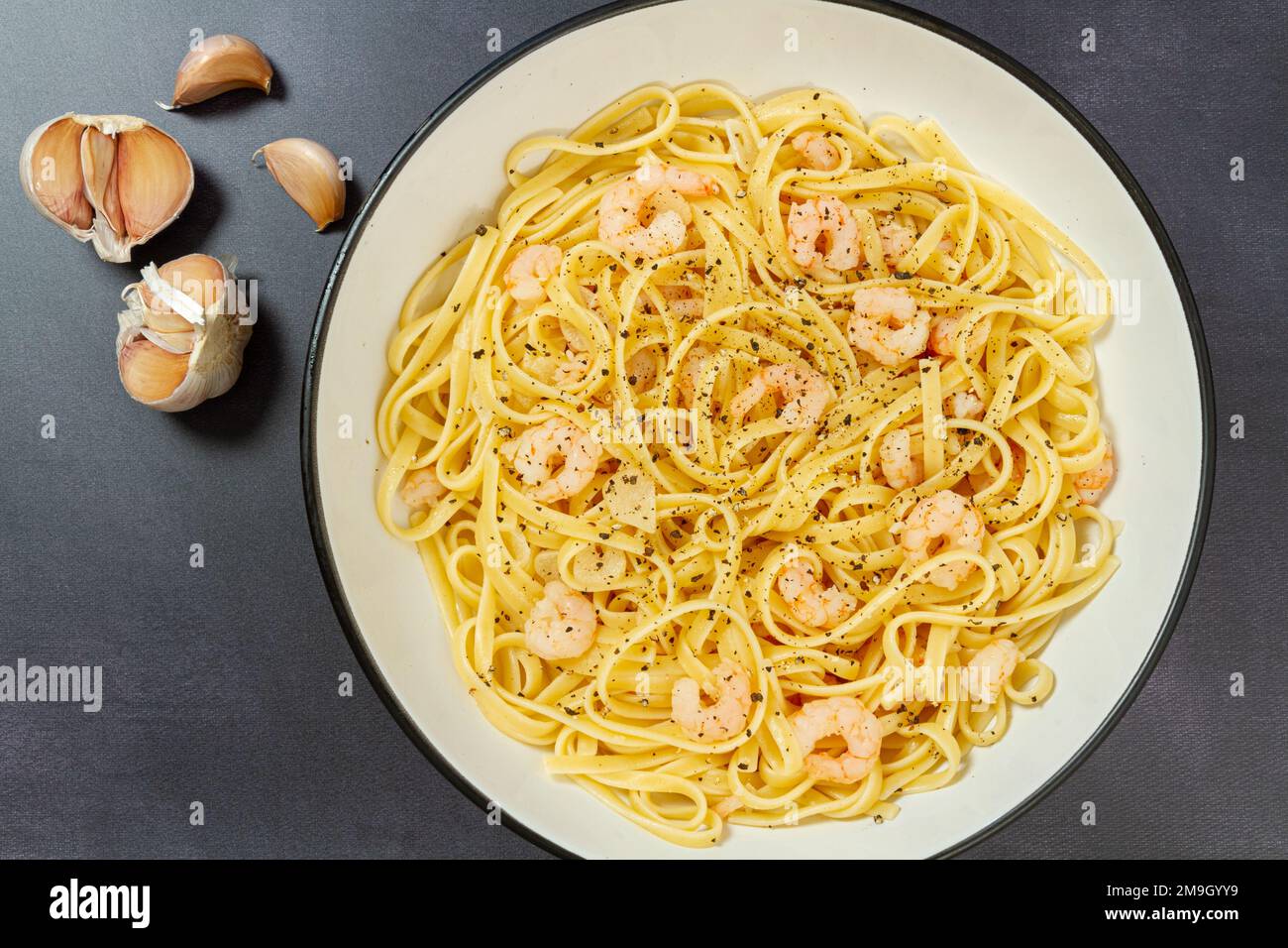 Linguine, Garnelen, Knoblauchzehen und schwarzer Pfeffer Stockfoto
