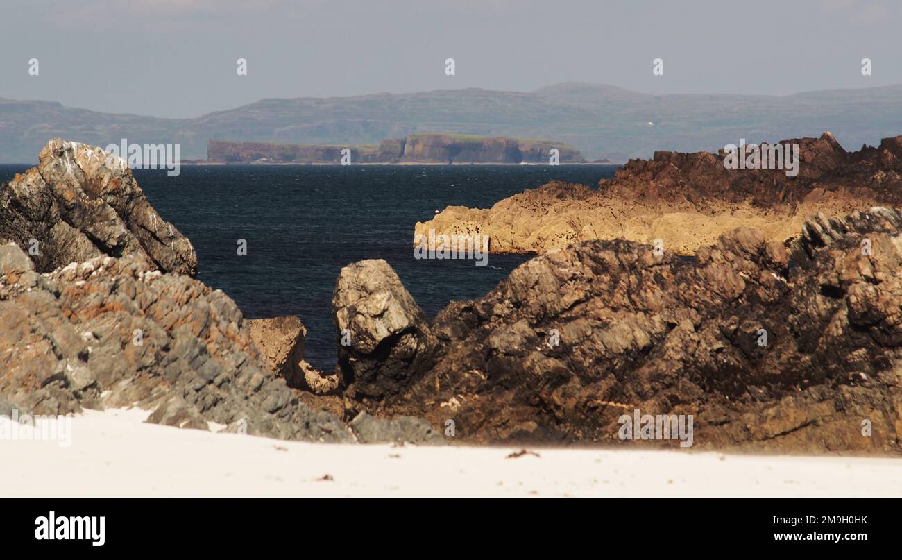 White Strand of the Monk's Beach, Iona, Schottland, Großbritannien, mit Blick auf Staffa, mit weißem Sand, zerklüfteten Felsen und farbenfrohem Meer Stockfoto