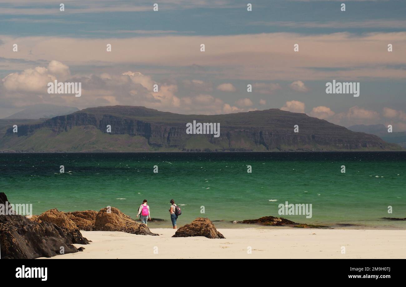 Zwei junge Frauen auf White Strand of the Monk's Beach, Iona, Schottland, Großbritannien, mit Blick über den Sound of Iona bis Mull an einem sonnigen Sommertag Stockfoto