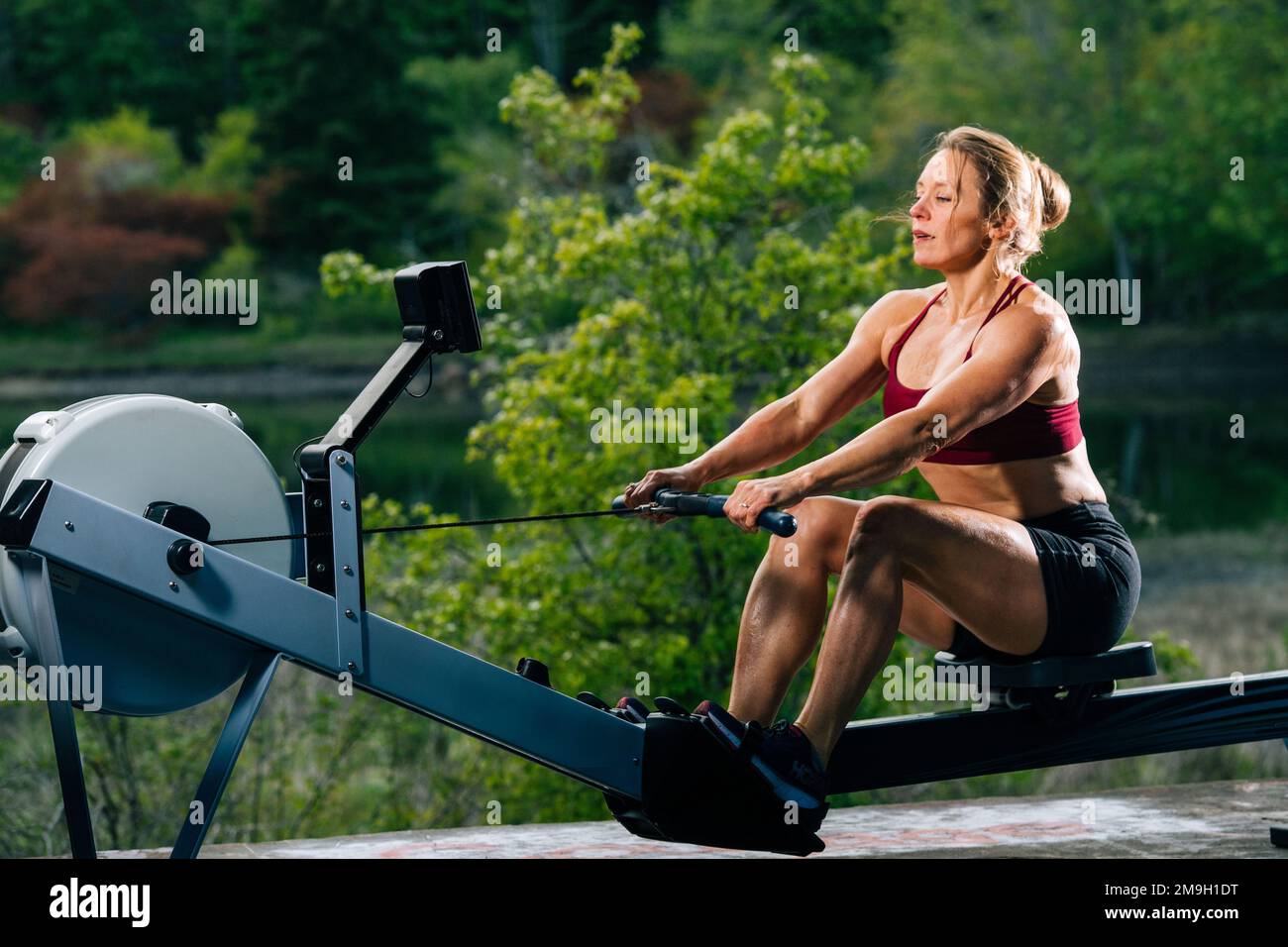 Frauen, die im Freien auf einer Rudermaschine trainieren, auf Bainbridge Island, Washington, USA Stockfoto