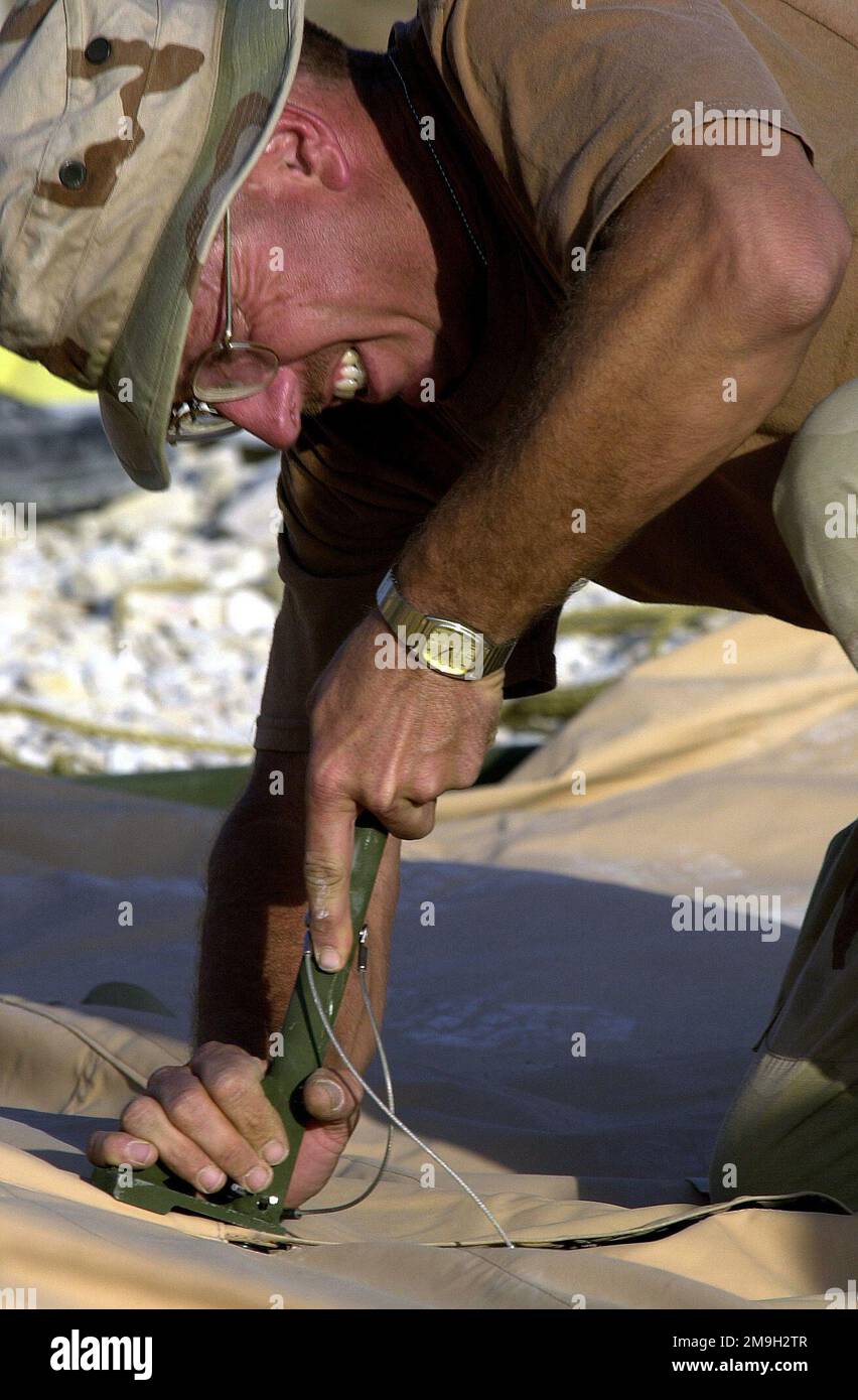 Terry Brancheau, Technical Sergeant (TSGT), ein Techniker für Bodengeräte aus dem 49. Material Maintenance Squadron, Holloman AFB, New Mexico, setzt einen Ridge Extender ein, bevor der Dachabschnitt eines TEMPER-Zelts (Zelte, Extendible, Modular, Personal) gesichert wird. TSGT Brancheau und andere Mitarbeiter der Luftwaffe bauen eine weitere Zeltstadt, die bald für Truppen errichtet wird, die zur Unterstützung der Operation DAUERHAFTE FREIHEIT in das Gebiet entsandt werden. Als Reaktion auf die Terroranschläge vom 11. September 2001 im New Yorker World Trade Center und im Pentagon leitete Präsident George W. Bush die Operation ein Stockfoto