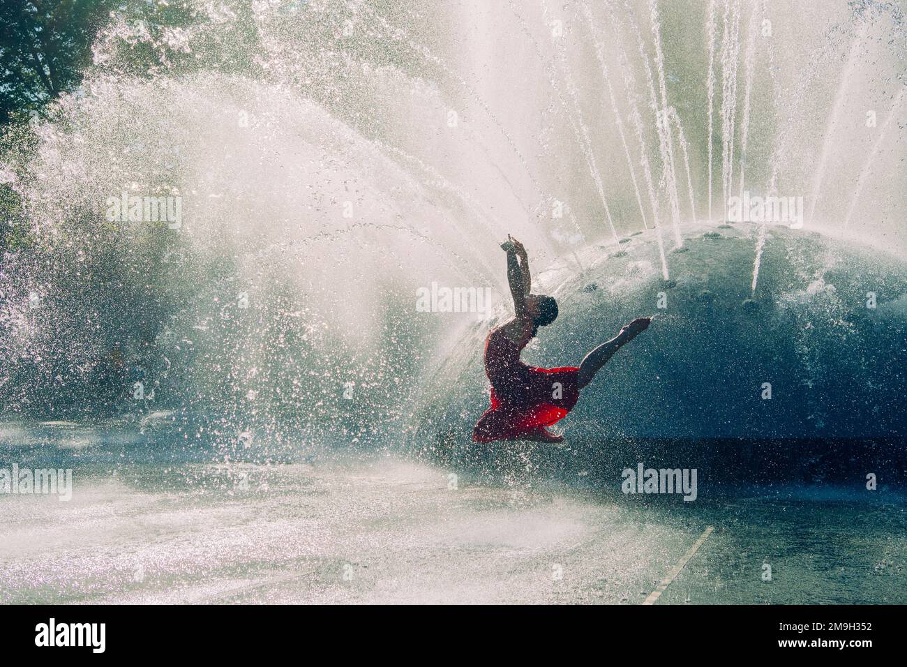 Balletttänzerin in rotem Kleid, tanzt im Springbrunnen, International Fountain, Seattle, Washington State, USA Stockfoto