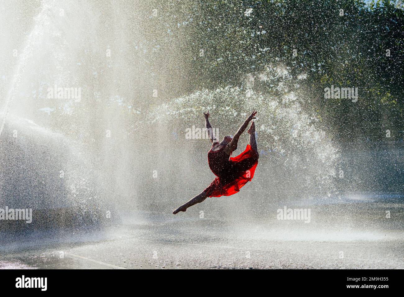 Balletttänzerin in rotem Kleid, tanzt im Springbrunnen, International Fountain, Seattle, Washington State, USA Stockfoto