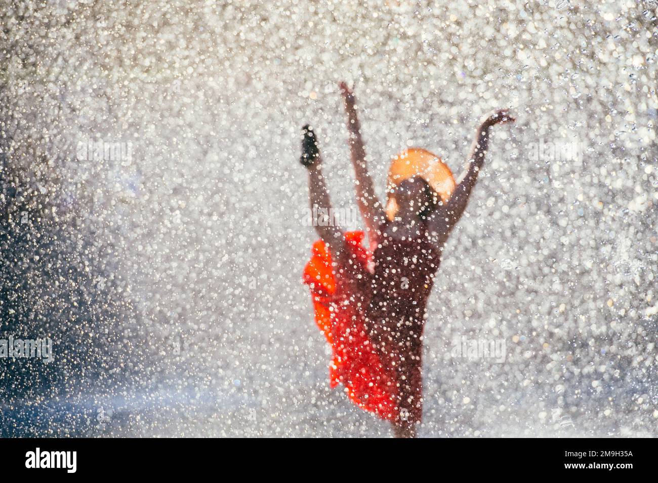 Frau in rotem Kleid, die im Brunnen, International Fountain, Seattle, Washington State, USA tanzt Stockfoto