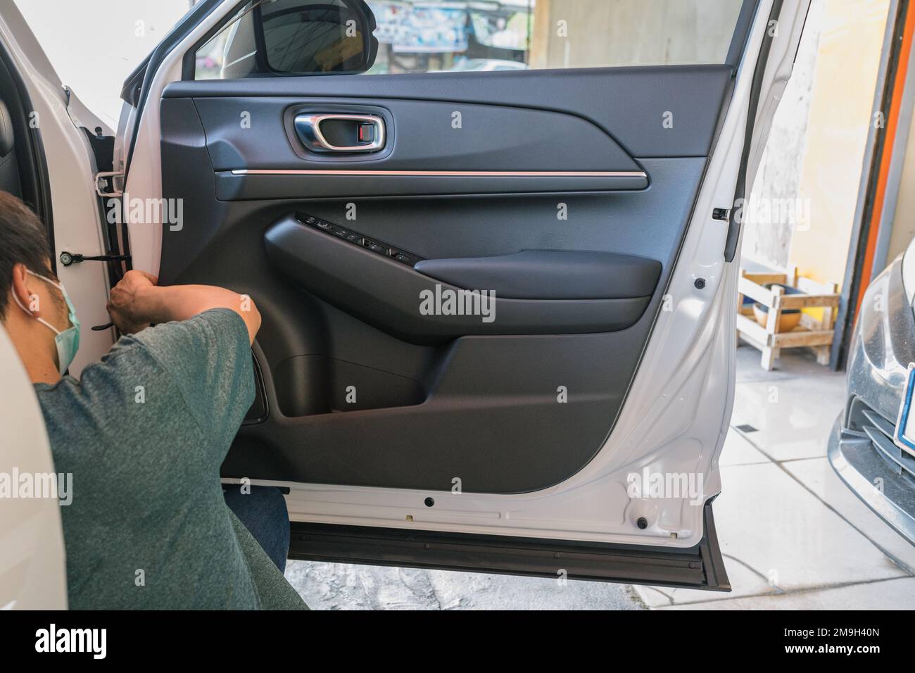 Mechaniker auspacken Fahrzeugtüren aus, um Fahrzeugprobleme in der Garagenwerkstatt zu prüfen Stockfoto