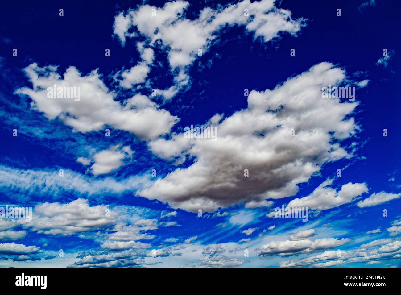 Flauschige Wolken am blauen Himmel Stockfoto
