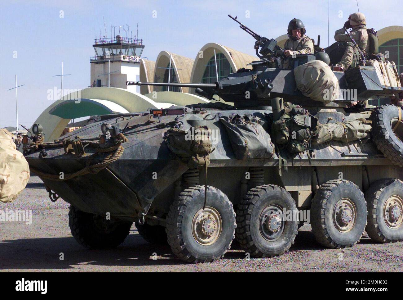 Marines der Alpha Company, 2D Light Panzeraufklärungsgesellschaft, dem Bataillonsmandeteam 3/6, 26. Marine Expeditionary Unit (Special Operations Capable) angeschlossen, bereiten ihr leichtes Rüstungsfahrzeug (LAV)-25 für Patrouillen um den Internationalen Flughafen Khandahar während DER OPERATION DAUERHAFTE FREIHEIT vor. Der Khandahar-Kontrollturm ist im Hintergrund. Ein Marine ist bereit, das 7,62-mm-Maschinengewehr auf dem M242 25mm-mm-Kettengewehr im Geschützturm zu bemannt. Subjekt Operation/Serie: DAUERHAFTE FREIHEITSBASIS: Internationaler Flughafen Kandahar Land: Szene Afghanistan (AFG) Hauptkommando gezeigt: 26. Stockfoto