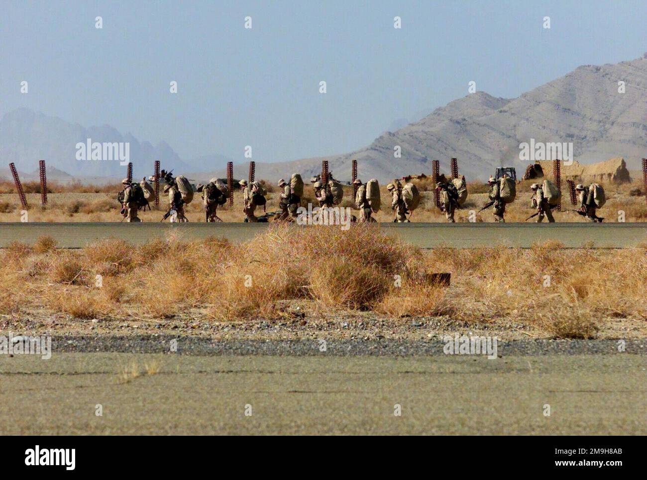 Marines des Bataillon Landing Team 3/6 (BLT 3/6) „humpeln“ während DER OPERATION „DAUERHAFTE FREIHEIT“ in Richtung ihrer Kampfschützenlöcher gleich neben der Landebahn am internationalen Flughafen Khandahar, Khandahar, Afghanistan. Betreff Operation/Serie: DAUERHAFTE FREIHEITSBASIS: Internationaler Flughafen Kandahar Land: Szene in Afghanistan (AFG) Hauptkommando gezeigt: 26. MEU (SOC) Stockfoto