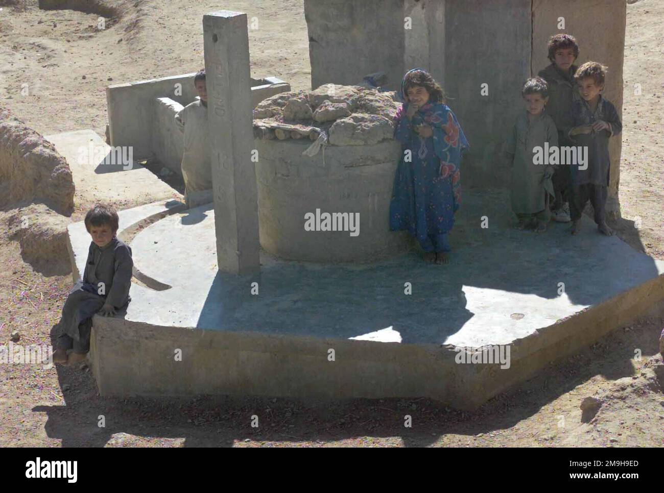 Afghanische Kinder versammeln sich im Brunnen des Dorfes, um Marines bei DER OPERATION DAUERHAFTE FREIHEIT mit leichten gepanzerten Fahrzeugen (LAV-25) durch ein Dorf in der Nähe des internationalen Flughafens Kandahar, Kandahar, Afghanistan, zu beobachten. Betreff Operation/Serie: DAUERHAFTE FREIHEITSBASIS: Internationaler Flughafen Kandahar Land: Afghanistan (AFG) Stockfoto