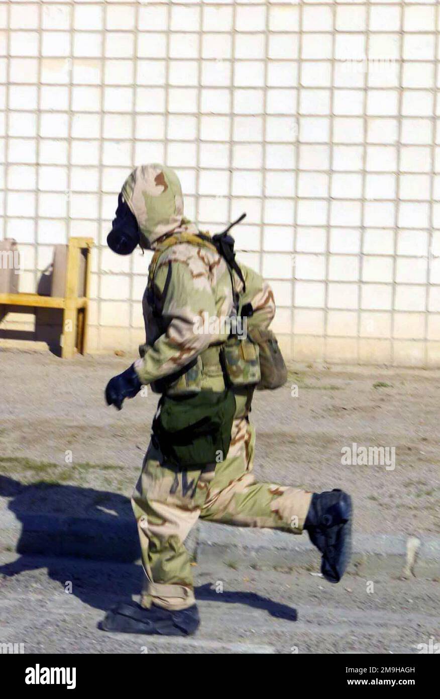In der Wüstenhitze rast ein Marine aus der Combined Joint Task Force (CJTF) zurück zur Ziellinie, während er in seinem Nuclear Biological Chemical (NBC)-Anzug sitzt. Der Marine trägt seine Joint Service Lightweight Integrated Suit Technology (JSLIST) und trägt eine chemisch-biologische Feldmaske M40 mit einem Filterkanister C2A1. Er nimmt während der Operation DAUERHAFTE FREIHEIT an einer NBC-Ausbildung im Camp Doha, Kuwait, Teil. Subjekt Operation/Serie: DAUERHAFTE FREIHEITSBASIS: Camp Doha Land: Szene Kuwait (KWT) Hauptkommando gezeigt: CJTF Stockfoto