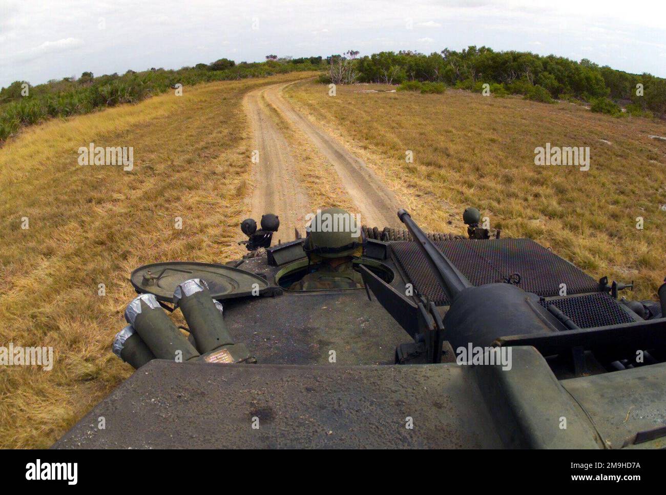 Ein Blick aus dem Turm als Marine der Charlie Company 1. Light Armored Reconnaissance (LAR) „war Pigs“ von der Marine Expeditionary Unit (Special Operations Capable) 13. (MEU (SOC)) fährt das Light Parmed Vehicle-25 (LAV-25) auf einer staubigen Straße während DES EDGED MALLET '02 in Kenia, Afrika. Die Kettenpistole LAVS M242 25mm ist deutlich sichtbar. Einsatzgebiet/Serie: KANTENHAMMER '02 Basis: Marinestützpunkt Manda Bay Bundesstaat: Küstenland: Kenia (KEN) Szene Hauptkommando gezeigt: 13 MEU Stockfoto