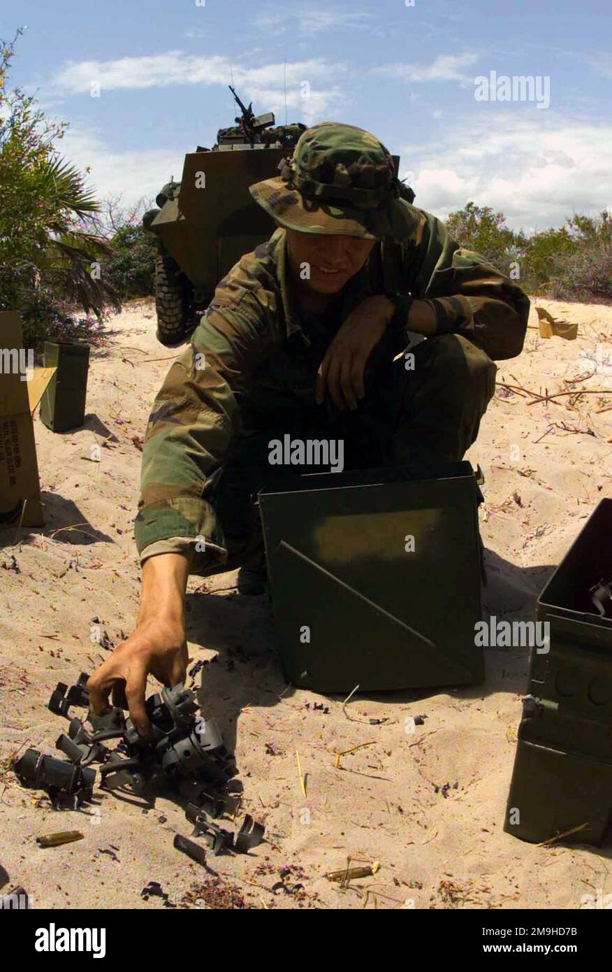 Lance Corporal George H. Burton, USMC, Driver, Charlie Company 1. Light Armored Reconnaissance (LAR) „war Pigs“ von der 13. Marine Expeditionary Unit (Special Operations Capable) (MEU (SOC)), räumt während eines Telefongesprächs mit Messing und Müll auf, nachdem er eine Feuerschulung am EDGED MALLET '02 in Kenia, Afrika, absolviert hat. Einer der leichten gepanzerten Fahrzeuge 25 (LAV-25) befindet sich hinter ihm. Einsatzgebiet/Serie: KANTENHAMMER '02 Basis: Marinestützpunkt Manda Bay Bundesstaat: Küstenland: Kenia (KEN) Szene Hauptkommando gezeigt: 13 MEU Stockfoto