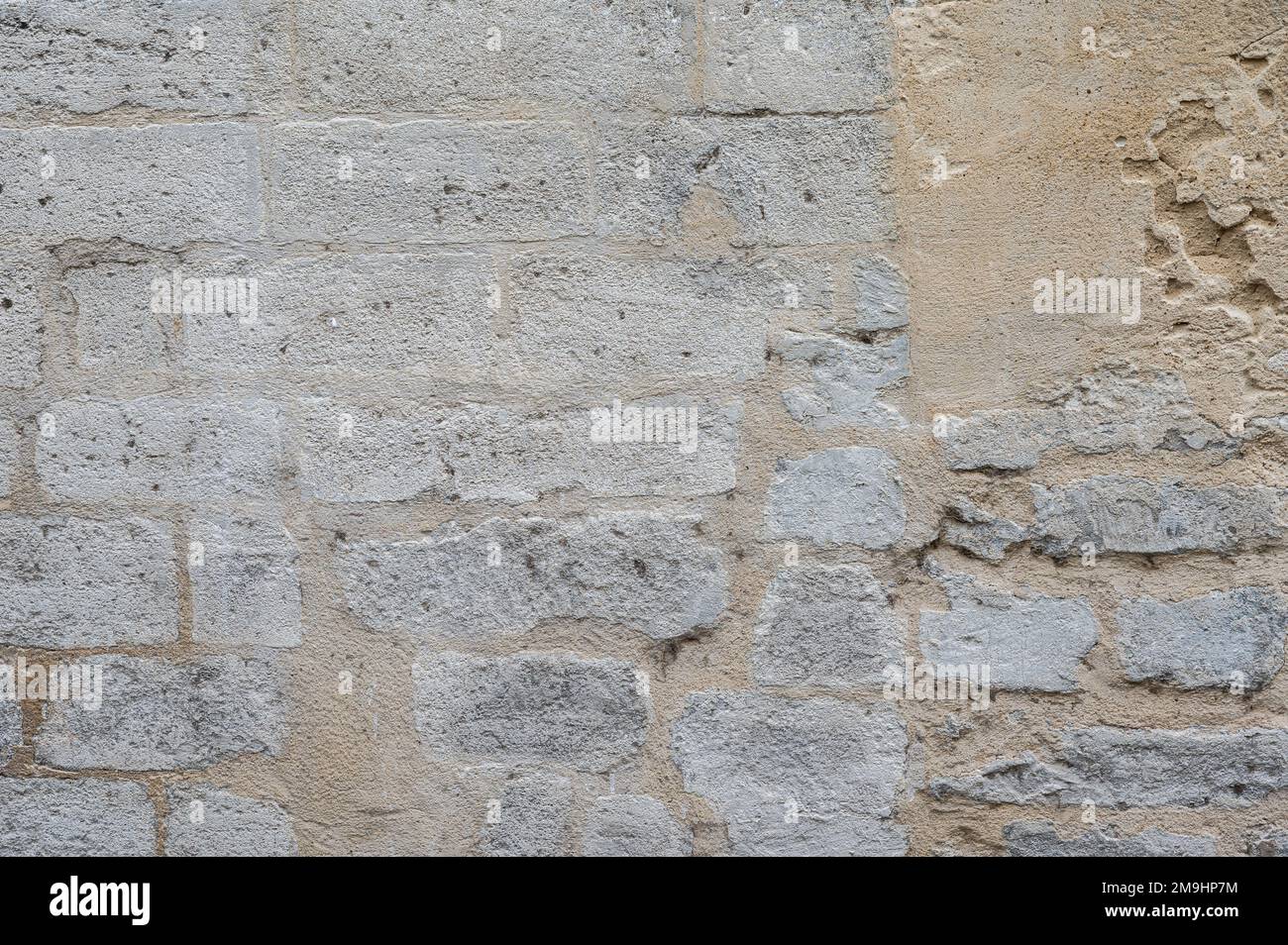 Strukturierte Steinwand in Grau- und Gelbtönen, Avignon, Frankreich Stockfoto