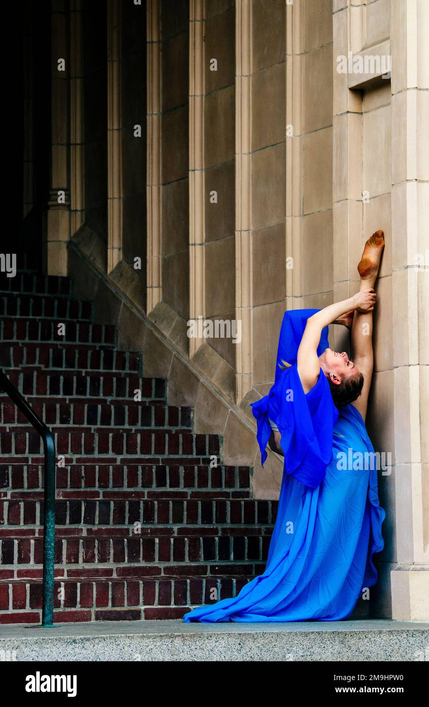 Akrobat in blauem Kleid, der sich auf der Treppe erstreckt, University of Washington, Seattle, Washington State, USA Stockfoto