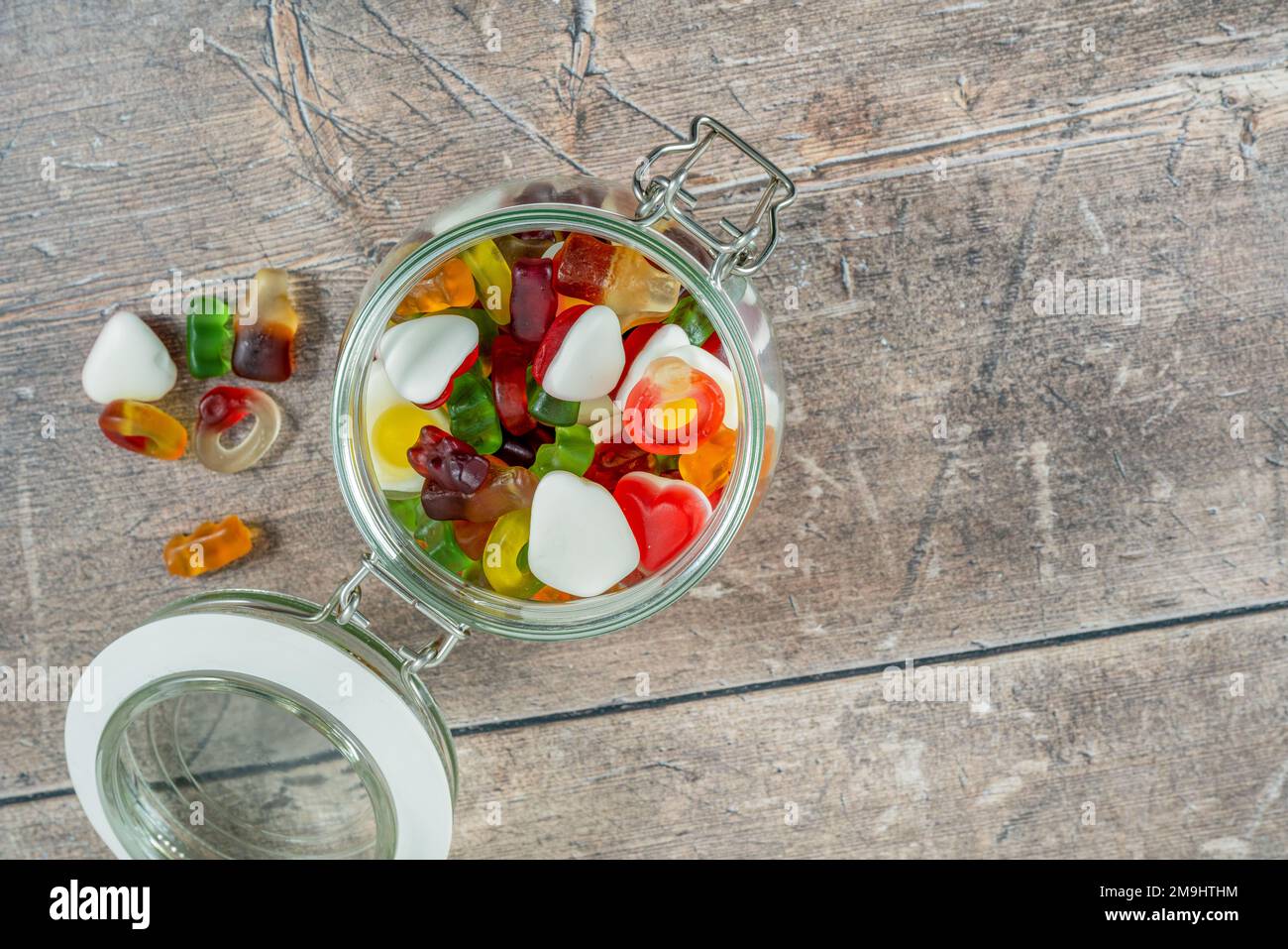 Süßigkeiten mit Fruchtgeschmack in Glasgefäß auf einem Holztisch Stockfoto