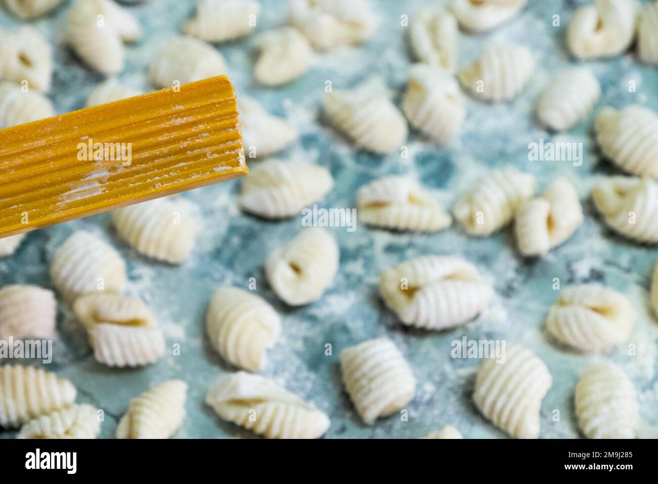 Sie kochen hausgemachte Gnocchi zum Mittagessen neben dem Werkzeug, um sie zuzubereiten Stockfoto