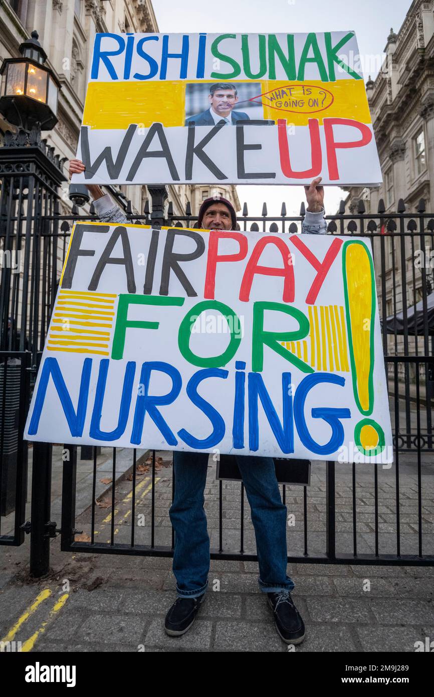 London, Großbritannien. 18. Januar 2023 Ein Mitglied des Royal College of Nursing (RCN) hält am ersten Tag eines zweitägigen Streiks, der von mehr als 55 NHS-Trusts in ganz England durchgeführt wird, Schilder vor der Downing Street. Der RCN fordert eine Gehaltserhöhung, damit der NHS Personal halten und einstellen kann. Die Krankenhäuser werden 4.500 nicht dringende Operationen und 25.000 ambulante Termine verschieben. Weitere Streiks sind für Februar geplant. Kredit: Stephen Chung / Alamy Live News Stockfoto