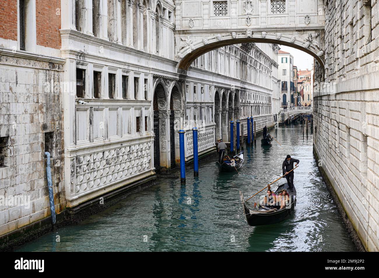 Drei Gondeln mit Touristen fahren in einem kleinen Kanal in der Altstadt von Venedig. Stockfoto