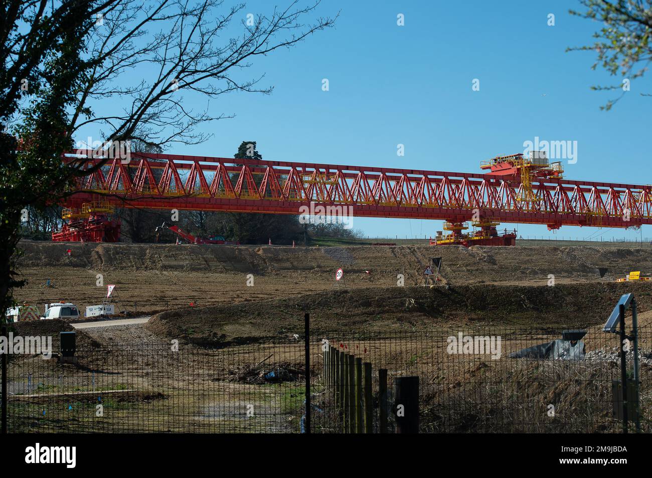 Denham, Großbritannien. 19. März 2022. HS2 Bauarbeiten für das Colne Valley Viadukt. Am ehemaligen Denham Water Ski Club neben der North Orbital Road in Denham werden Betonpiers aufgestellt. Die 700-Tonnen-Trägermaschine HS2 High Speed Rail mit dem Namen Dominique (abgebildet) ist jetzt in Betrieb und hat damit begonnen, einige der vorgegossenen Betonbrückensegmente auf das erste von 56 Pier-Segmenten für den HS2 High Speed 2 Colne Valley Viaduct zu bringen. Das Colne Valley Viaduct wird die längste Eisenbahnbrücke in Großbritannien sein. Kredit: Maureen McLean/Alamy Stockfoto