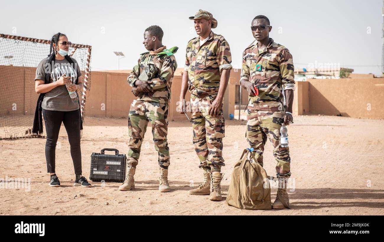 Soldaten der nigrischen Streitkräfte (Französisch: Streitkräfte Streitkräfte Nigeriennes – FAN) hören einem Dolmetscher zu, der während einer gemeinsamen Übung mit den USA über ein Trainingsszenario für improvisierte Sprengkörper (C-IED) spricht Techniker der Air Force für die Sprengstoffbeseitigung, die der 409. Air Expeditionary Group auf dem GENIE Compound DES FANS in Agadez, Niger, am 19. Mai 2022 zugeteilt wurden. Diese gemeinsamen C-IED-Schulungen finden zweimal pro Woche statt, was es sowohl den FANS als auch den US-Streitkräften ermöglicht, ihre Fähigkeiten zu verfeinern und zu stärken und so die Sicherheit und Stabilität für die Regierung von Niger und ihre Bürger zu erhöhen Stockfoto