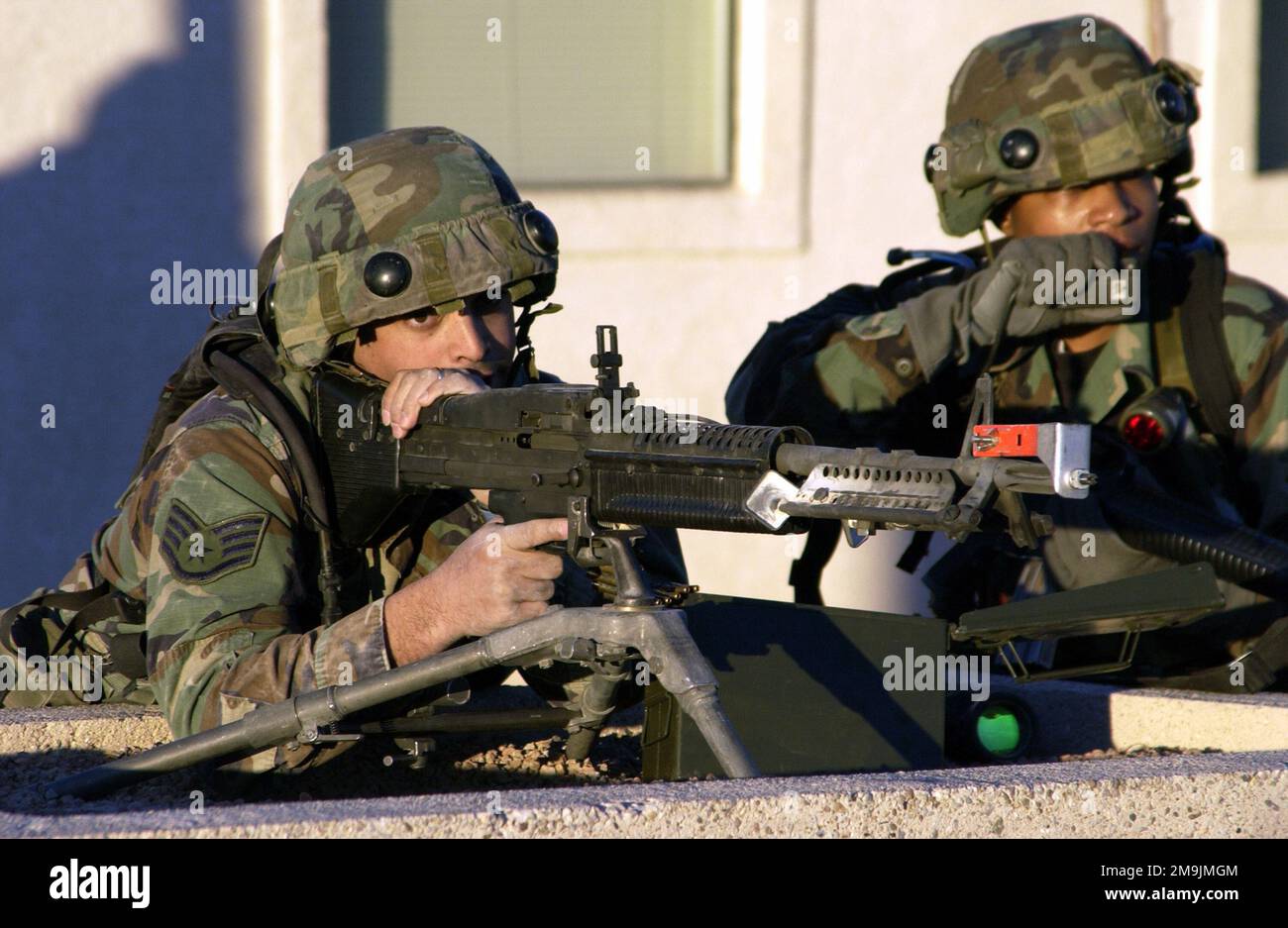 030116-F-1789V-004. [Complete] Szene Caption: US Air Force (USAF) STAFF Sergeant (SSGT) Michael Morales zielt mit seinem Saco 7,62mm M60-Mehrzweckmaschinengewehr auf Eindringlinge, die versuchen, das Vordertor zu betreten. USAF Technical Sergeant (TSGT) Mary Long, bittet um Unterstützung während einer Silver Flag Alpha Trainingsübung am Indian Springs Air Force Auxiliary Air Field, Nevada (NV). Beide sind mit dem 116. Sicherheitsgeschwader (SFS), der Air National Guard (ANG), dem Luftwaffenstützpunkt Robins (AFB) und Georgia (GA) zusammen und tragen als Teil des Traini mehrere integrierte Laser-Einsatzsysteme (MEILEN) Stockfoto