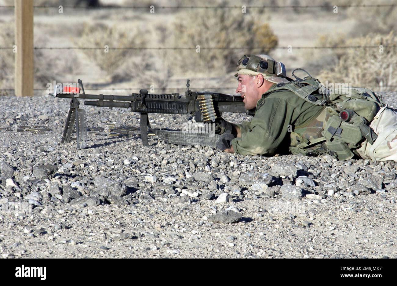 030117-F-1789V-010. [Complete] Szene Caption: US Air Force (USAF) STAFF Sergeant (SSGT) Corey Connor, Ausbilder, Air Base Defense School, 99. Bodengefechtsstaffel (GCTS), Indian Springs Air Force Auxiliary Air Field (AAF), Nevada (NV), Erwidert das Feuer und gibt sich als Gegner aus, der während eines Silver Flag Alpha Trainings versucht, einen nach vorne ausgesetzten Luftwaffenstützpunkt zu infiltrieren. SSGT Connor trägt ein Multiple Integrated Laser Engagement System (MILES), das erkennt, ob die Verteidiger ihn getroffen haben. Außerdem ist er mit einer universellen Saco 7,62 mm M60 Maschinenpistole mit MEILEN-Anbaugeräten ausgerüstet. Der Zug 99. GCTS Stockfoto
