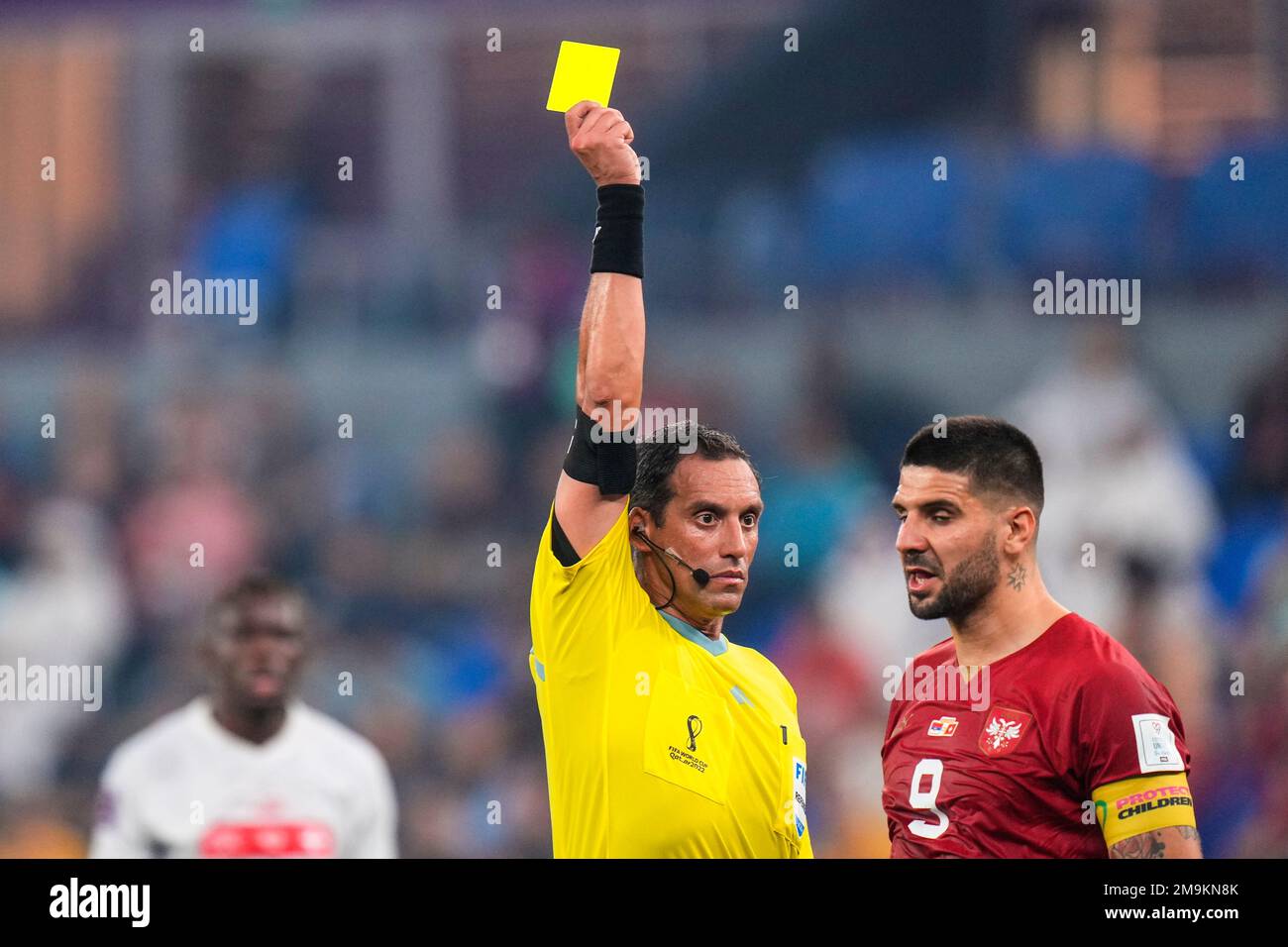 Referee Fernando Rapallini displays a yellow card to Serbia's Aleksandar Mitrovic during the