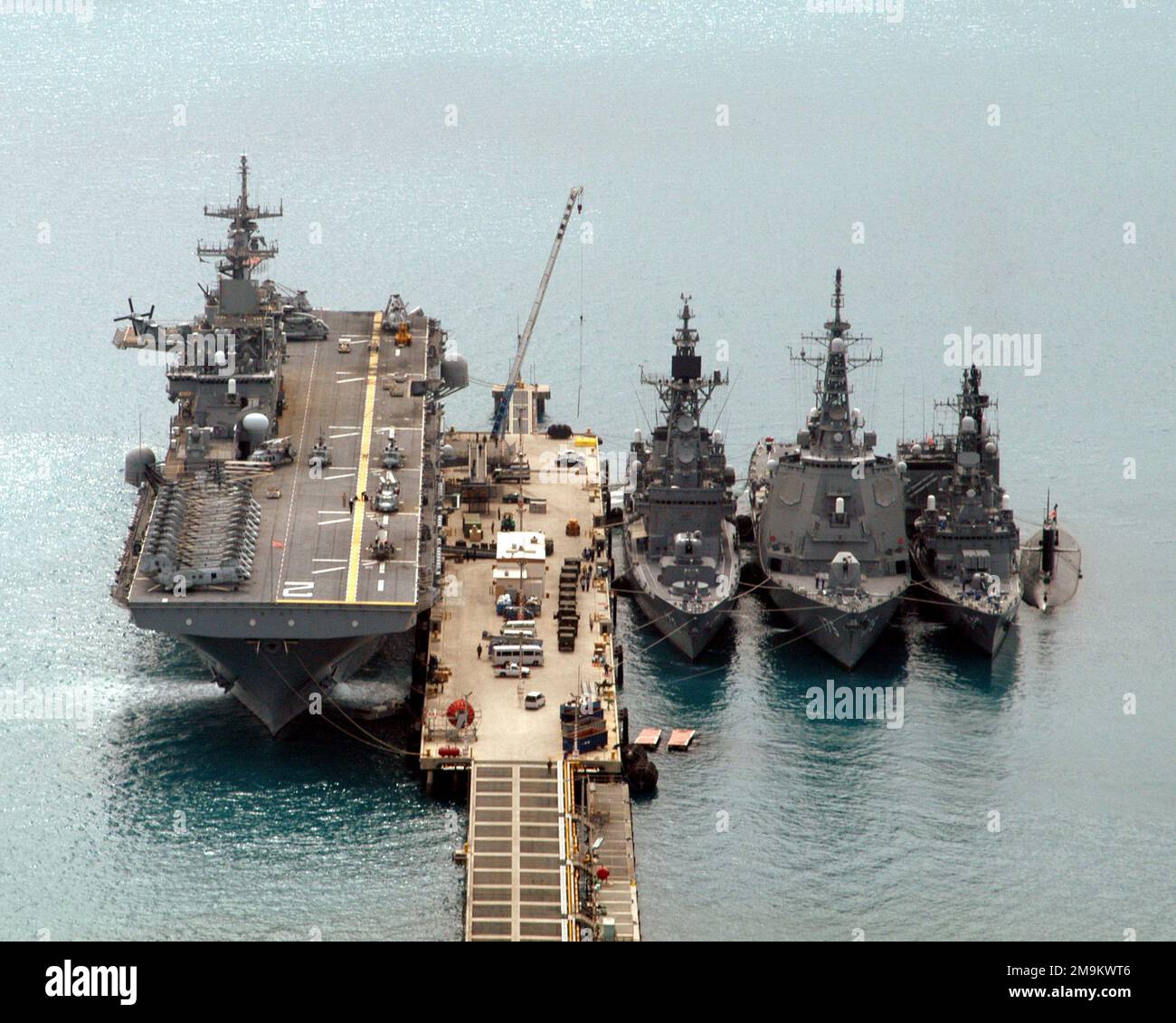 Hochwinkel, Bug-on-View, zeigt Schiffe der US Navy (USN) und der japanischen Marine-Selbstverteidigungskräfte (JMSDF), die am Pier festgemacht und Seite an Seite an der White Beach Port Facility in Okinawa, Japan, festgemacht sind. Von links nach rechts abgebildet sind die USN WASP-KLASSE: Amphibienschiff, USS ESSEX (LHD 2 155), die JMSDF HATAKAZE-KLASSE: Destroyer, SHIMAKAZE (DDG 172 584), die JMSDF KONGOU-KLASSE: Destroyer, MYOUIRKOU (DDG 175), die JMSDF HAGIO (UNTERKLASSE HAGIO) und die JUSHARSAI (Unterklasse HAGI HARI (HAGI). Staat: Okinawa Land: Japan (JPN) Stockfoto