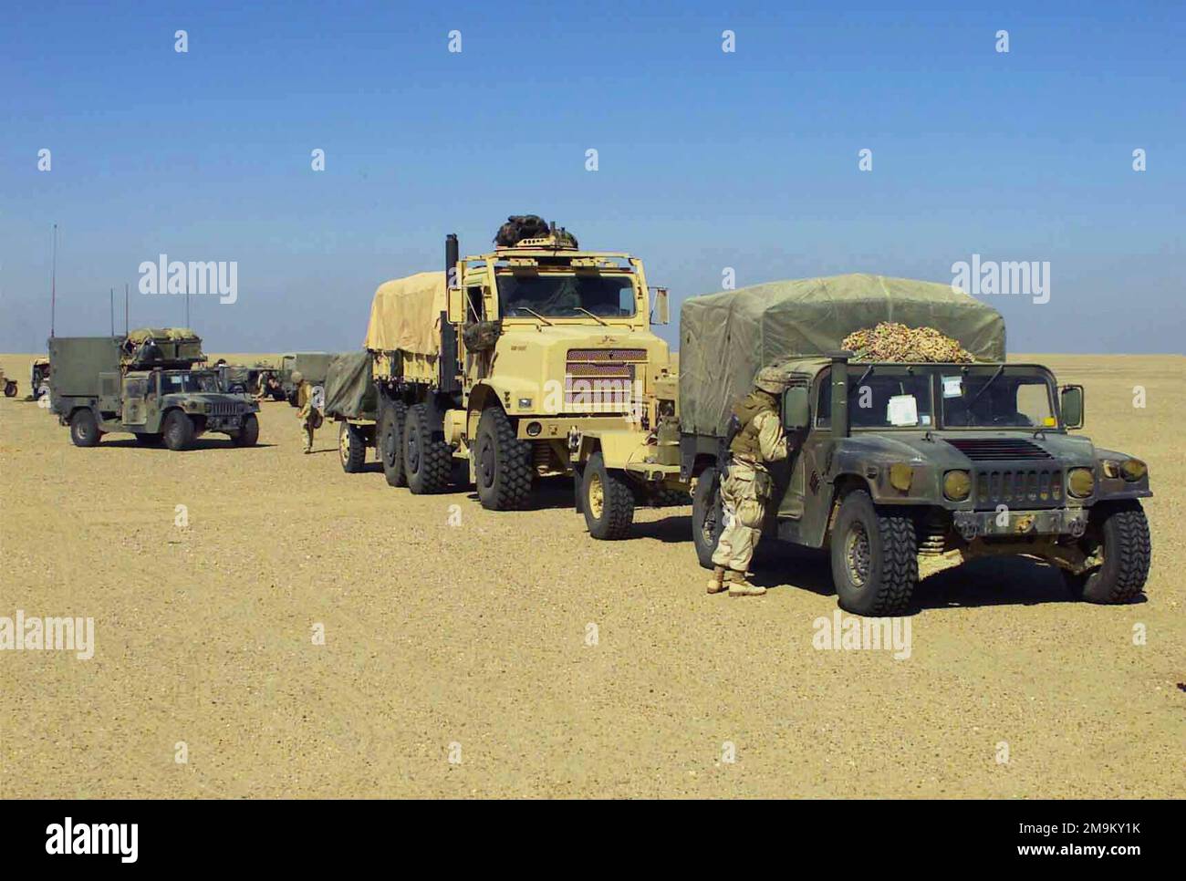 Eine Reihe von High Mobility Multi-Purpose Wheeled Vehicles (HMMWV) und Medium Tactical Replacement Vehicles (MTRV) des US Marine Corps (USMC) stellen sich in einem Konvoi auf, um eine Wanderung durch die offene Wüste zu ermöglichen und die dauerhafte EINSATZFREIHEIT zu unterstützen. Betreff Betrieb/Serie: LAND DER DAUERHAFTEN FREIHEIT: Kuwait (KWT) Stockfoto