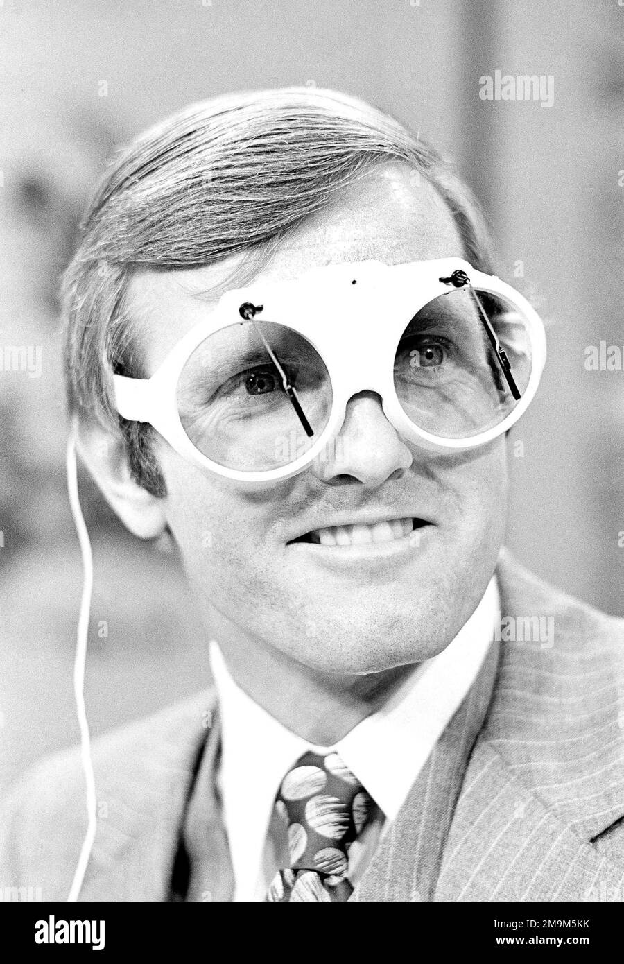 Miami Dolphin quarterback Bob Griese who earlier this season had problems with his contact lenses while playing, donned a pair of glasses with windshield wipers, Sept. 19, 1977, in Miami, Fla., as a joke while appearing on WPLG-TV in Miami which hosted the Don Shula Show. Griese seemed to have solved his eyeglass problems earlier as the Dolphins defeated the Buffalo Bills the night before but with regular glasses. (AP Photo/Phil Sandlin) Stockfoto