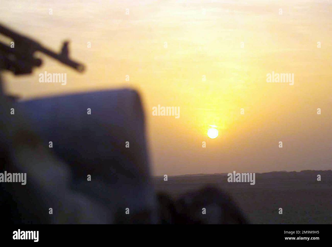 Ein Blick auf den Sonnenuntergang über der Kuwaitischen Wüste, von einem leichten gepanzerten Fahrzeug (LAV-25) des US Marine Corps (USMC) aus gesehen, das dem 1. Leichten gepanzerten Aufklärungsbataillon (LARB), 1. Marine Division, zugeteilt wurde und während der Operation DAUERHAFTE FREIHEIT patrouilliert. (Unterdurchschnittliches Bild). Land: Kuwait (KWT) Stockfoto