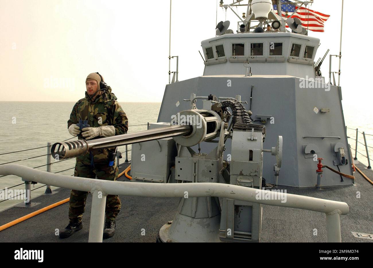 US Navy (USN) Engineman Third Class (EN3) Edward Bessette scannt den Horizont nach Kontakten und potenziellen Aggressoren vom Bug des Küstenpatrouillenboots USS CHINOOK (PC 9) der Zyklonklasse neben einem MK 38 25-mm-Maschinengewehr, um die Freiheit der Operation IRAQI zu unterstützen. Betreff Operation/Serie: IRAKISCHE FREIHEITSBASIS: USS Chinook (PC 9) Stockfoto