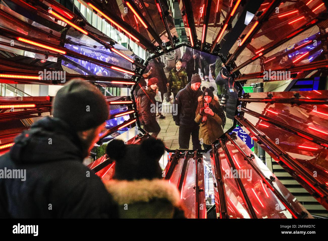 London, Großbritannien. 18. Januar 2023. Die Menschen sehen und fotografieren Out of the Dark von Tom Lambert, direkt vor dem Crossrail Place, einer audiovisuellen Lichtanlage, die Raum für Selbstreflexion und positive Einstellung bietet. Das jährliche Winter Lights Festival startet heute mit 22 Lichtinstallationen und beeindruckenden Kunstausstellungen rund um Canary Wharf in London. Das öffentliche Festival läuft bis zum 28. Januar und kann kostenlos besucht werden. Kredit: Imageplotter/Alamy Live News Stockfoto