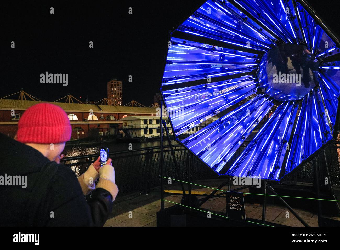 London, Großbritannien. 18. Januar 2023. Die Menschen sehen und fotografieren Out of the Dark von Tom Lambert, direkt vor dem Crossrail Place, einer audiovisuellen Lichtanlage, die Raum für Selbstreflexion und positive Einstellung bietet. Das jährliche Winter Lights Festival startet heute mit 22 Lichtinstallationen und beeindruckenden Kunstausstellungen rund um Canary Wharf in London. Das öffentliche Festival läuft bis zum 28. Januar und kann kostenlos besucht werden. Kredit: Imageplotter/Alamy Live News Stockfoto