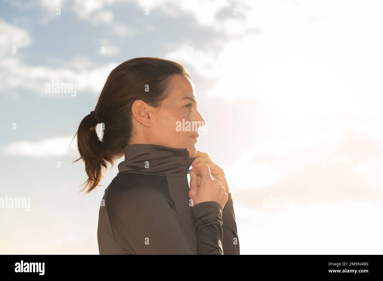 Eine sportliche Frau, die ihr Sporttop hochzieht Stockfoto