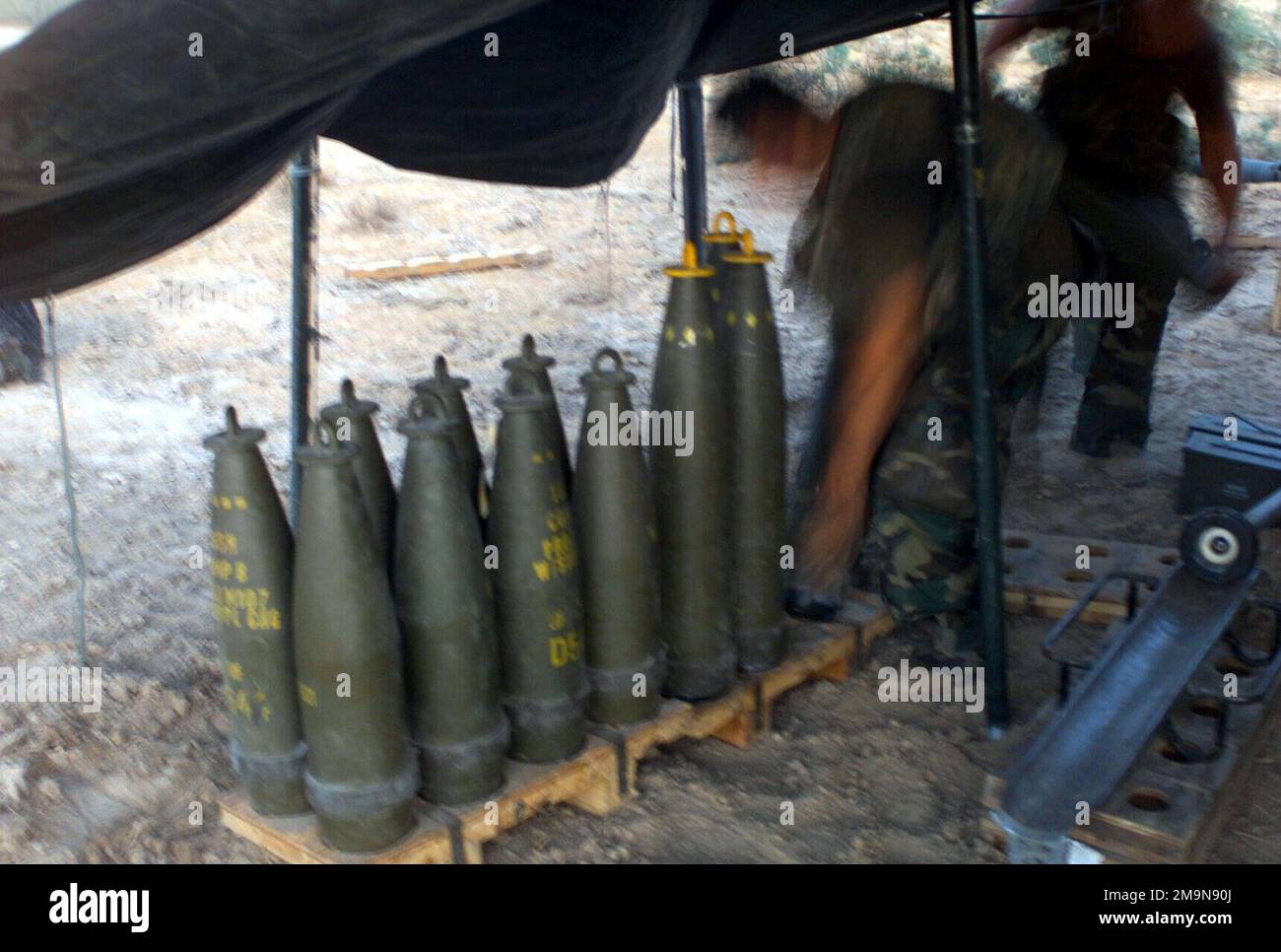US Marine Corps (USMC) Marines, die F/Battery zugewiesen wurden, Bataillonsmannschaft, 2. Bataillon, 2. Marines, 24. Marine Expeditionary Unit (MEU), Special Operations Capable (SOC), richteten Geschosse für ihren M198 155 mm langen Haubitzer unter einer Plane ein, um sie an einer Waffenposition im Irak vor der Sonne zu schützen. Während der Operation IST die IRAKISCHE FREIHEIT. (Unterdurchschnittliches Bild). Betreff Operation/Serie: IRAQI FREEDOM Country: Iraq (IRQ) Stockfoto