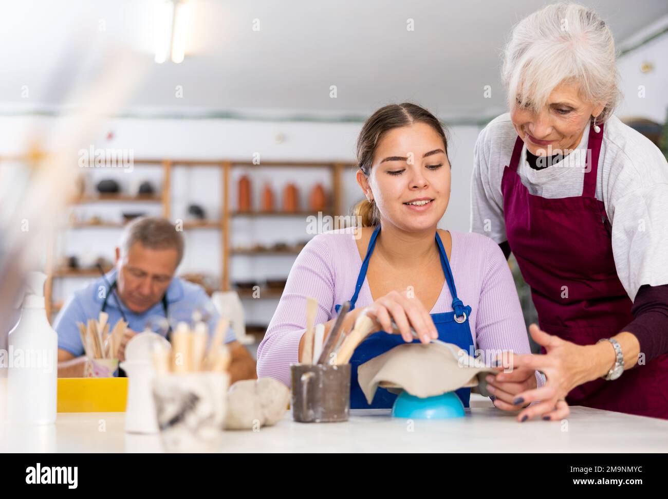 Professionelle Töpferinnen lehren junge Frauen Töpferei zu kreieren Stockfoto