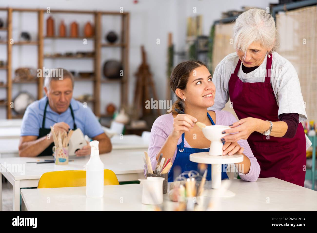 Professionelle Töpferinnen lehren junge Frauen Töpferei zu kreieren Stockfoto