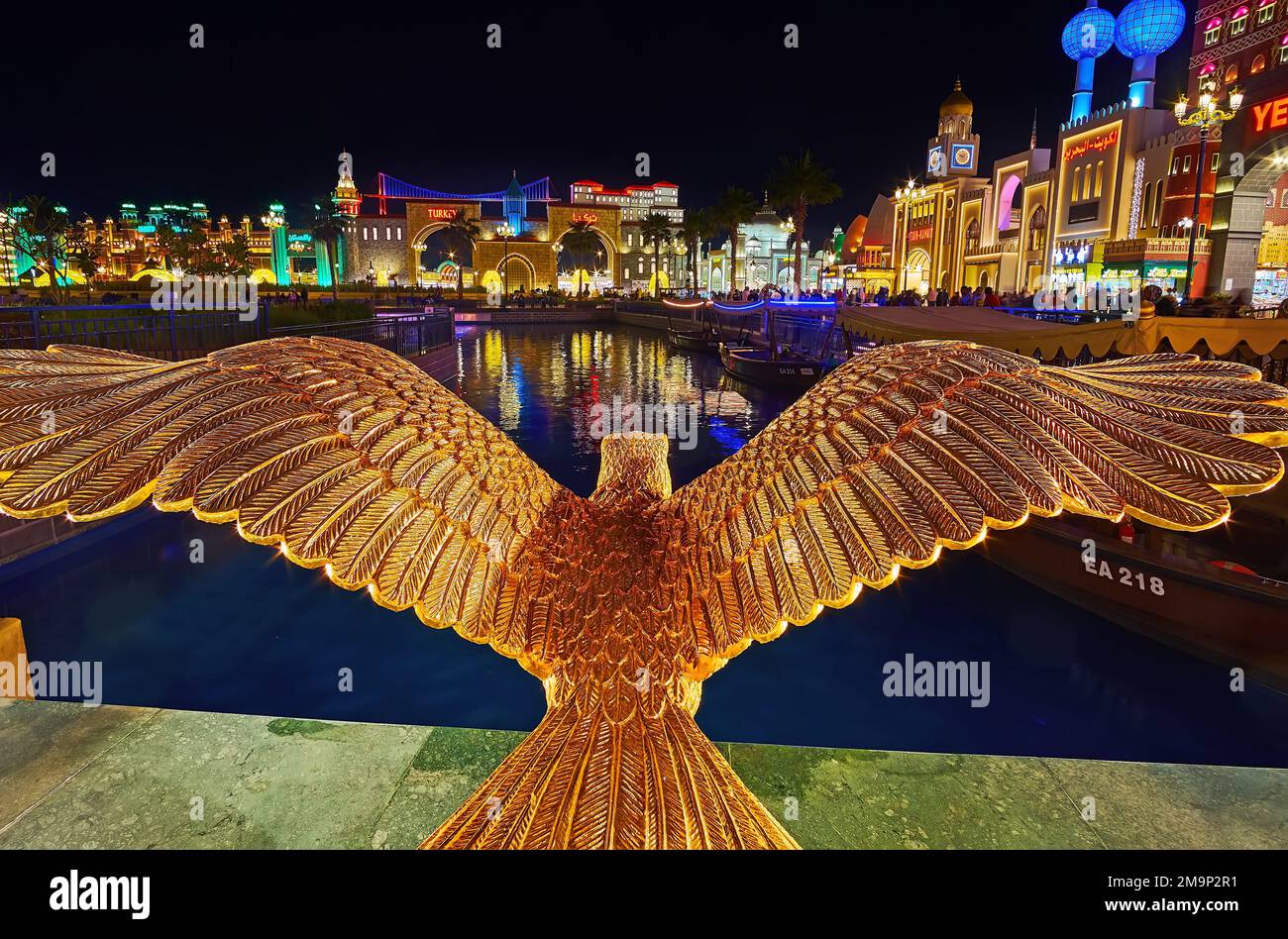 DUBAI, Vereinigte Arabische Emirate - 6. MÄRZ 2020: Die Skulptur des Goldenen Adlers vor den hell erleuchteten Pavillons des Global Village Dubai, am 6. März in Dubai Stockfoto