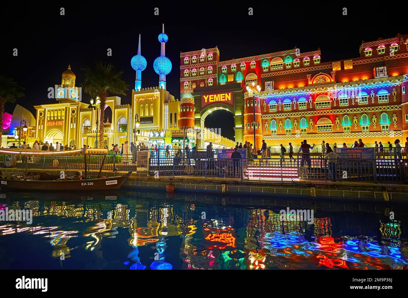 DUBAI, Vereinigte Arabische Emirate - 6. MÄRZ 2020: Beleuchtete Pavillons von Jemen und Kuwait, reflektiert auf den Gewässern des Kanals im Global Village Dubai, am 6. März in Dubai Stockfoto