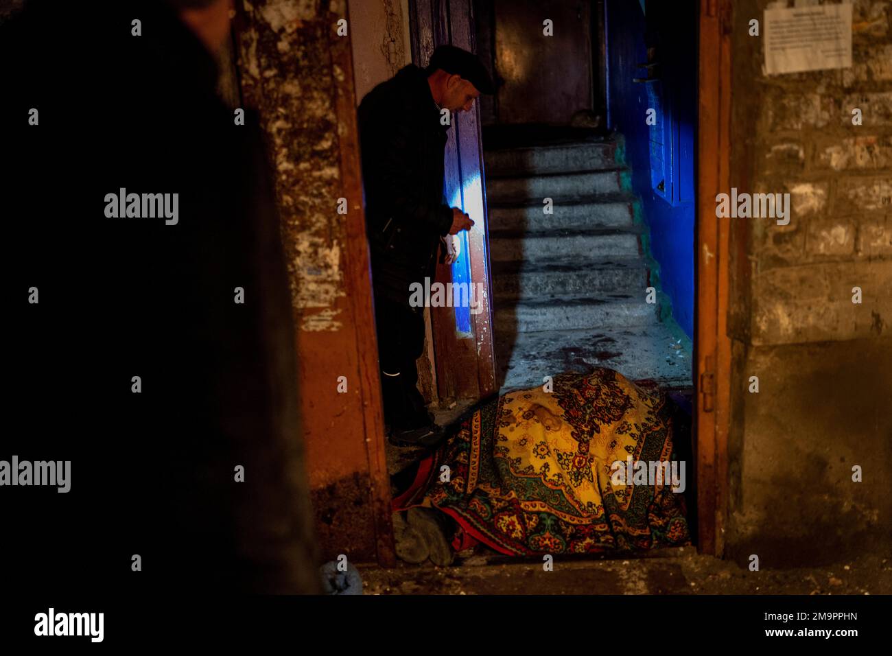 A man walks past the body of a woman killed during a Russian attack in Kherson, southern Ukraine, Thursday, Nov. 24, 2022. (AP Photo/Bernat Armangue) Stockfoto