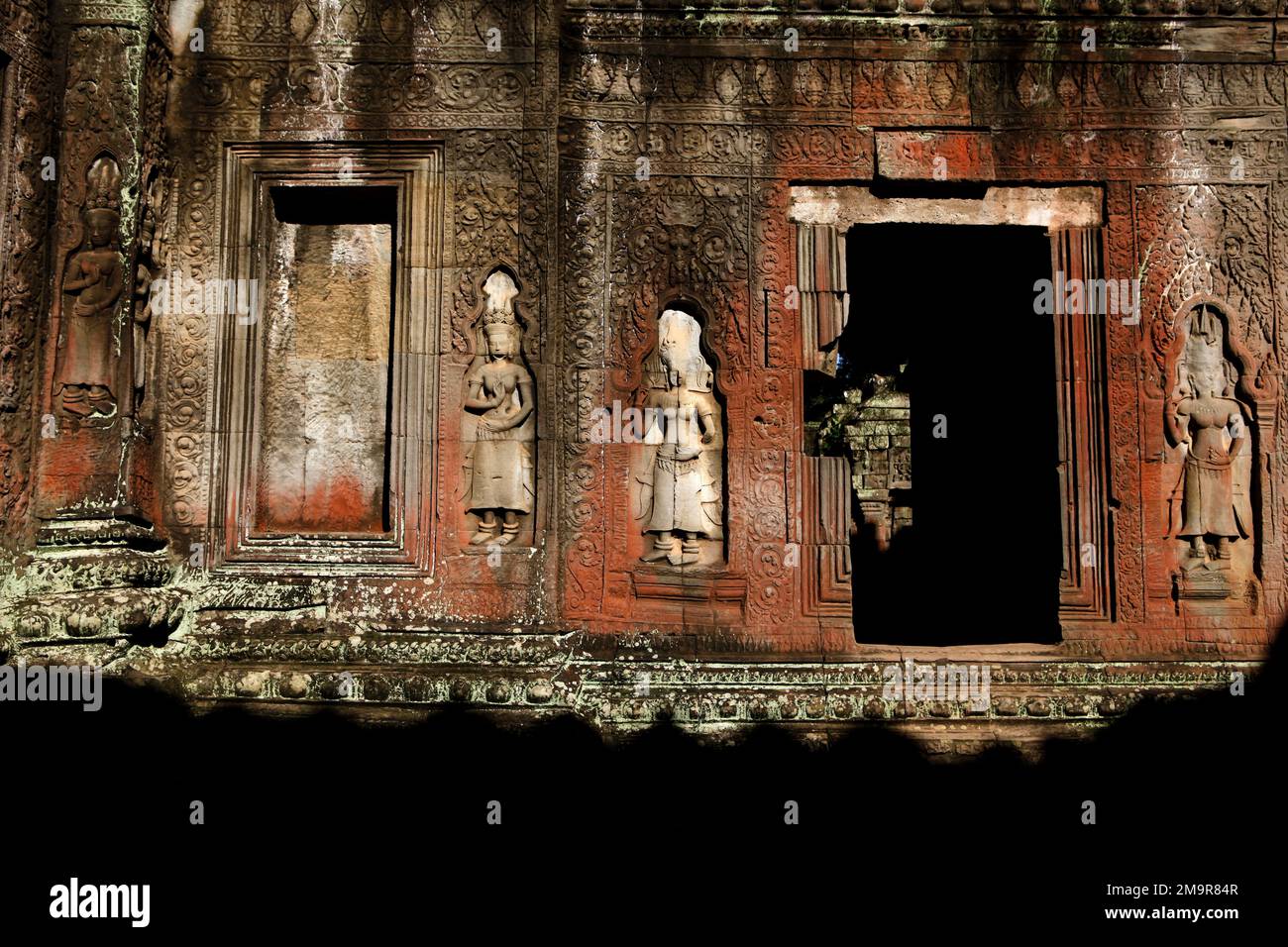 Eine mit apsara-Reliefs geschmückte Mauer in Ta Prohm, einem alten Kloster und Tempel in Siem Reap, Kambodscha. Stockfoto