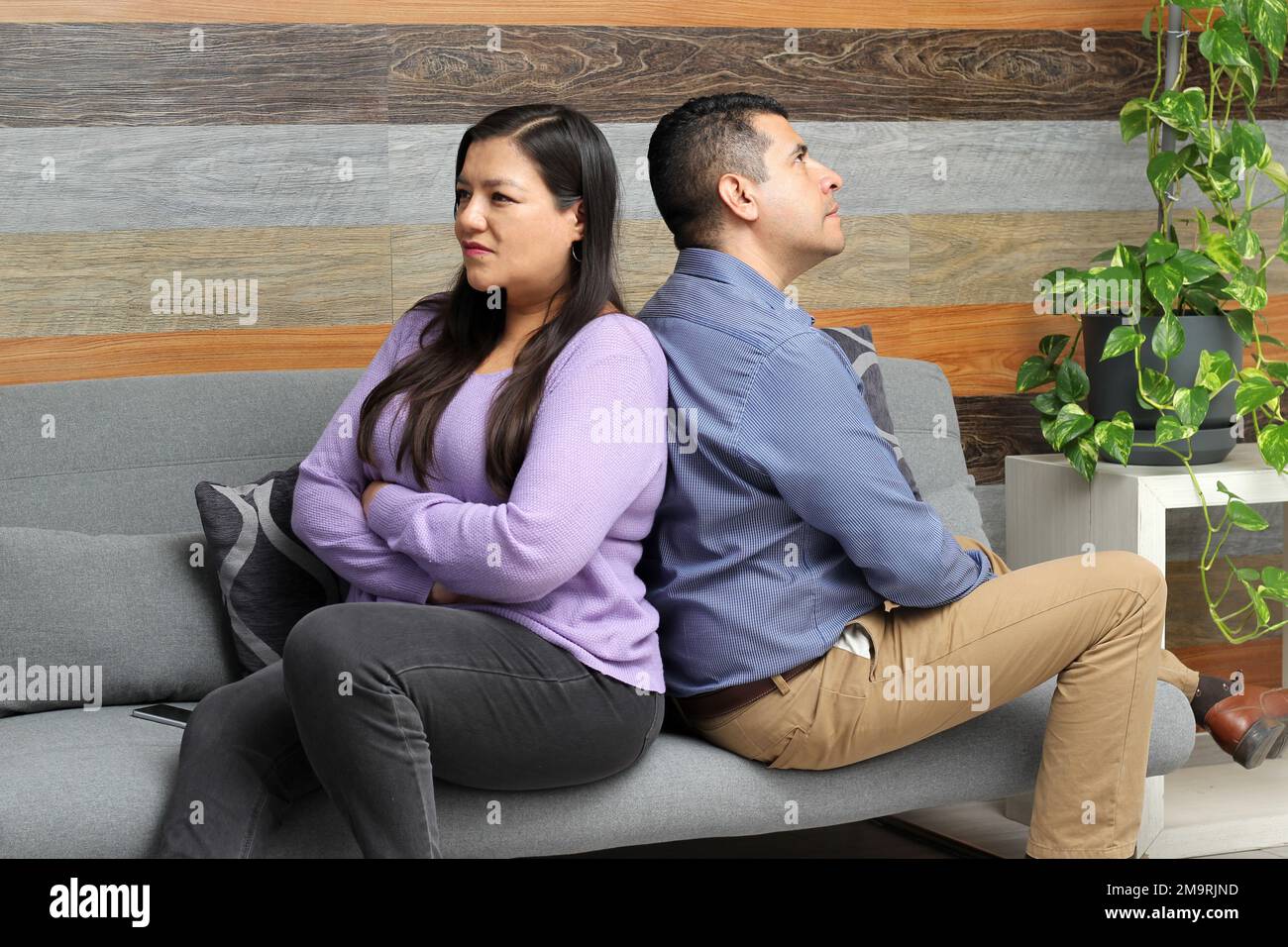 Ein erwachsenes Paar aus Latino, das auf dem Sofa sitzt, ist verärgert und wütend über Probleme, die zu ihrer Trennung führen können Stockfoto